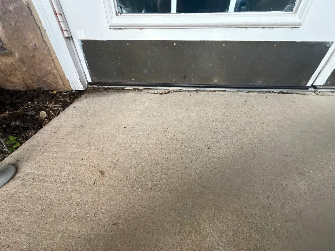 Close view of a door’s lower weather seal at the threshold.